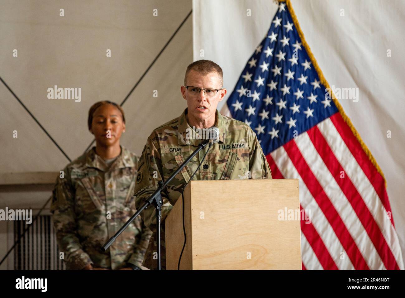 U.S. Army Lt. Col. Lewis Gray, the commander of the 336th Combat Sustainment Support Battalion, speaks to the attendees during a ceremony in which the 336th CSSB transferred authority to the 382nd CSSB. Standing behind him was Maj. Ciera Earley, the executive officer of the battalion. These battalions are subordinate to the 369th Sustainment Brigade while forward deployed to the CENTCOM area of operations. Stock Photo