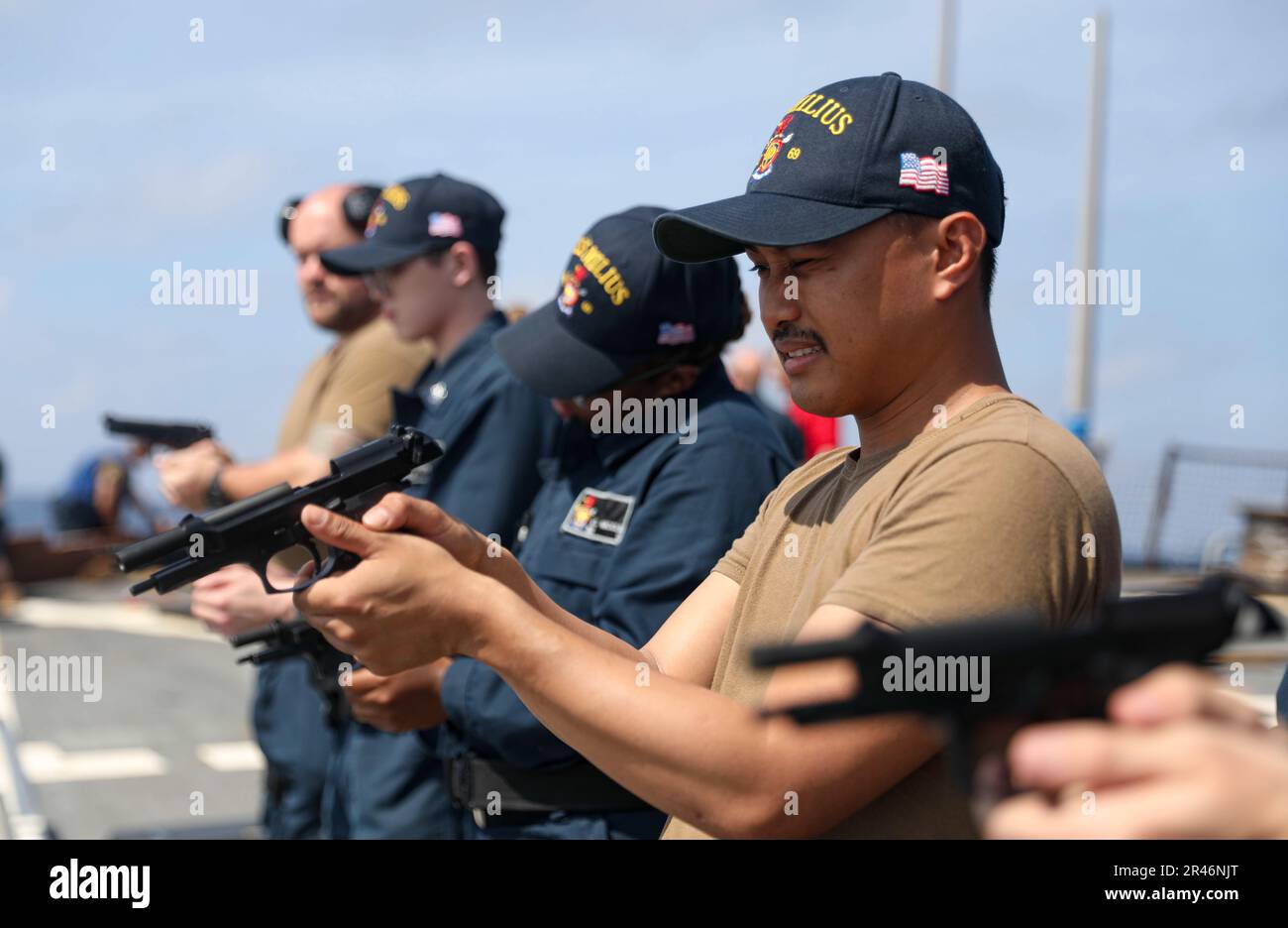 SOUTH CHINA SEA (March 27, 2023) – Retail Sales Specialist 3rd Class Amador Capuno, from XXXXX, XXXXXXX, inspects a 9 mm pistol during weapons familiarization training aboard the Arleigh Burke-class guided-missile destroyer USS Milius (DDG 69) while operating in the South China Sea, March 27. Milius is assigned to Commander, Task Force 71/Destroyer Squadron (DESRON) 15, the Navy’s largest forward-deployed DESRON and the U.S. 7th Fleet’s principal surface force. Stock Photo