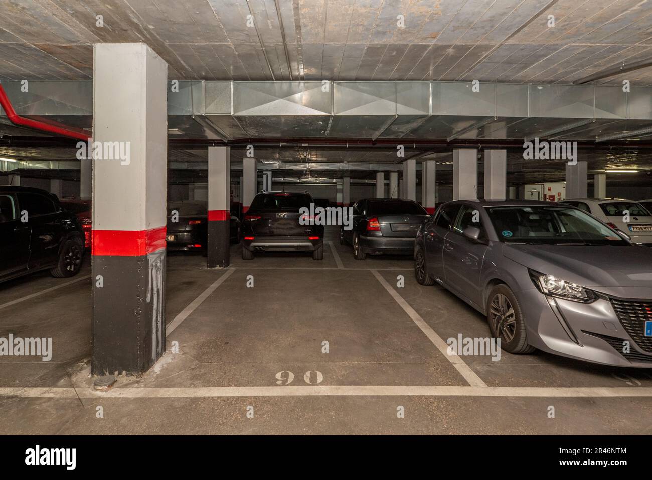 A dark garage with parked cars and free spaces Stock Photo