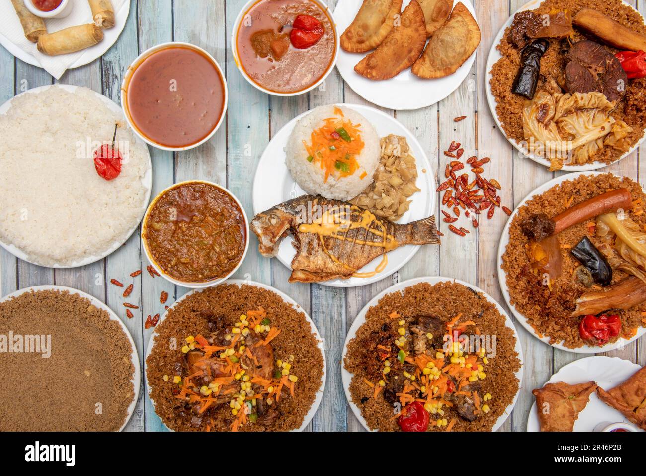 Set of assorted African food dishes with fried fish, patties, stews and white rice Stock Photo