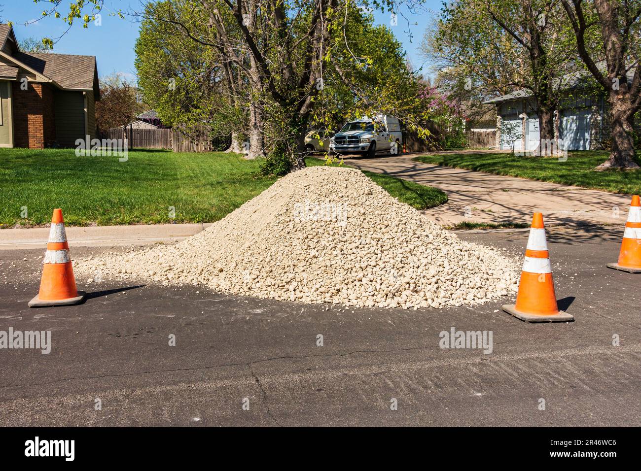 A pile of rocks for landscaping or construction in the street with orange traffic cones marking it off. Kansas, USA. Stock Photo