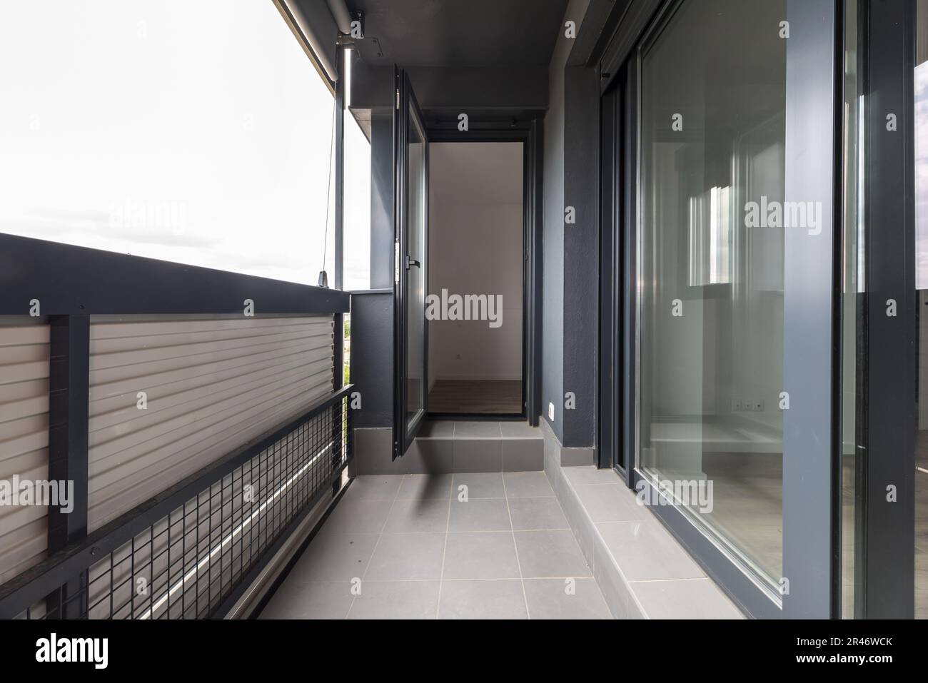 Small terrace with gray aluminum sliding doors and one folding Stock