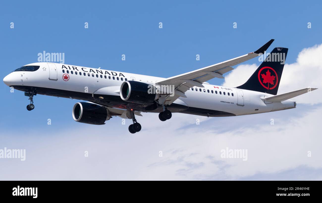 An Air Canada aircraft soaring against a blue sky backdrop Stock Photo ...
