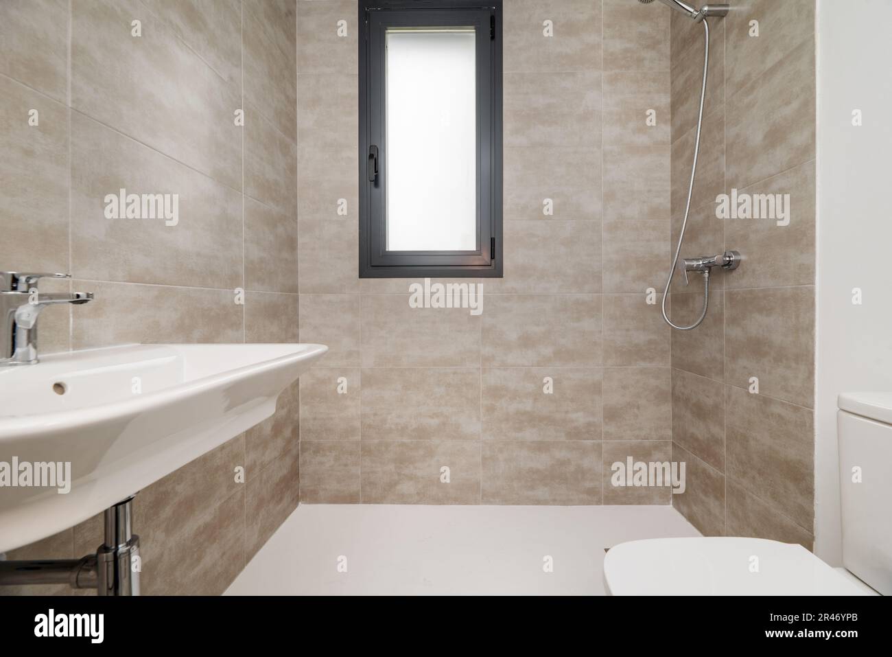 A small toilet room with a window, a shower cabin without a screen and