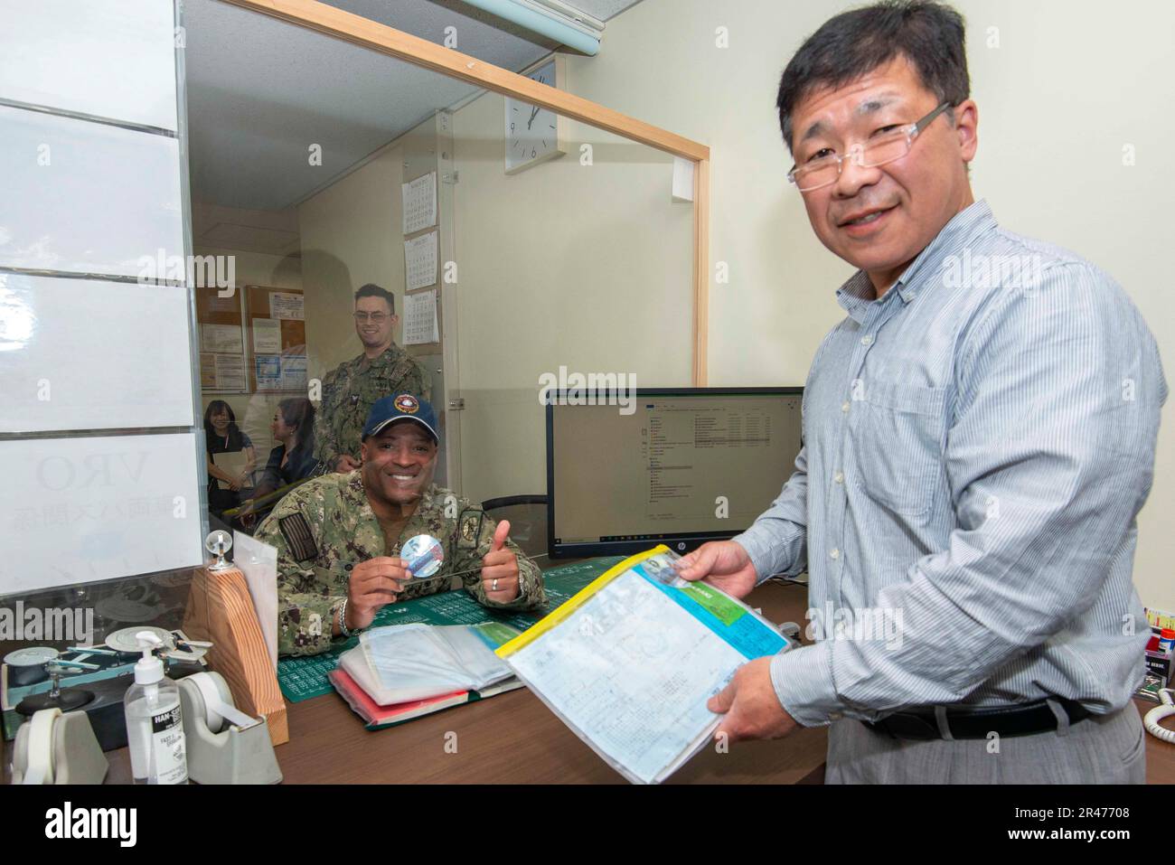 Capt. David Adams, Commander, Fleet Activities Sasebo (CFAS), receives his 2023 road tax sticker from Yasushi Koga at the CFAS vehicle registration office April 10, 2023. The CFAS security department hosts an annual road tax campaign for drivers at CFAS to simplify the process of paying the government of Japan’s annual road tax. Stock Photo