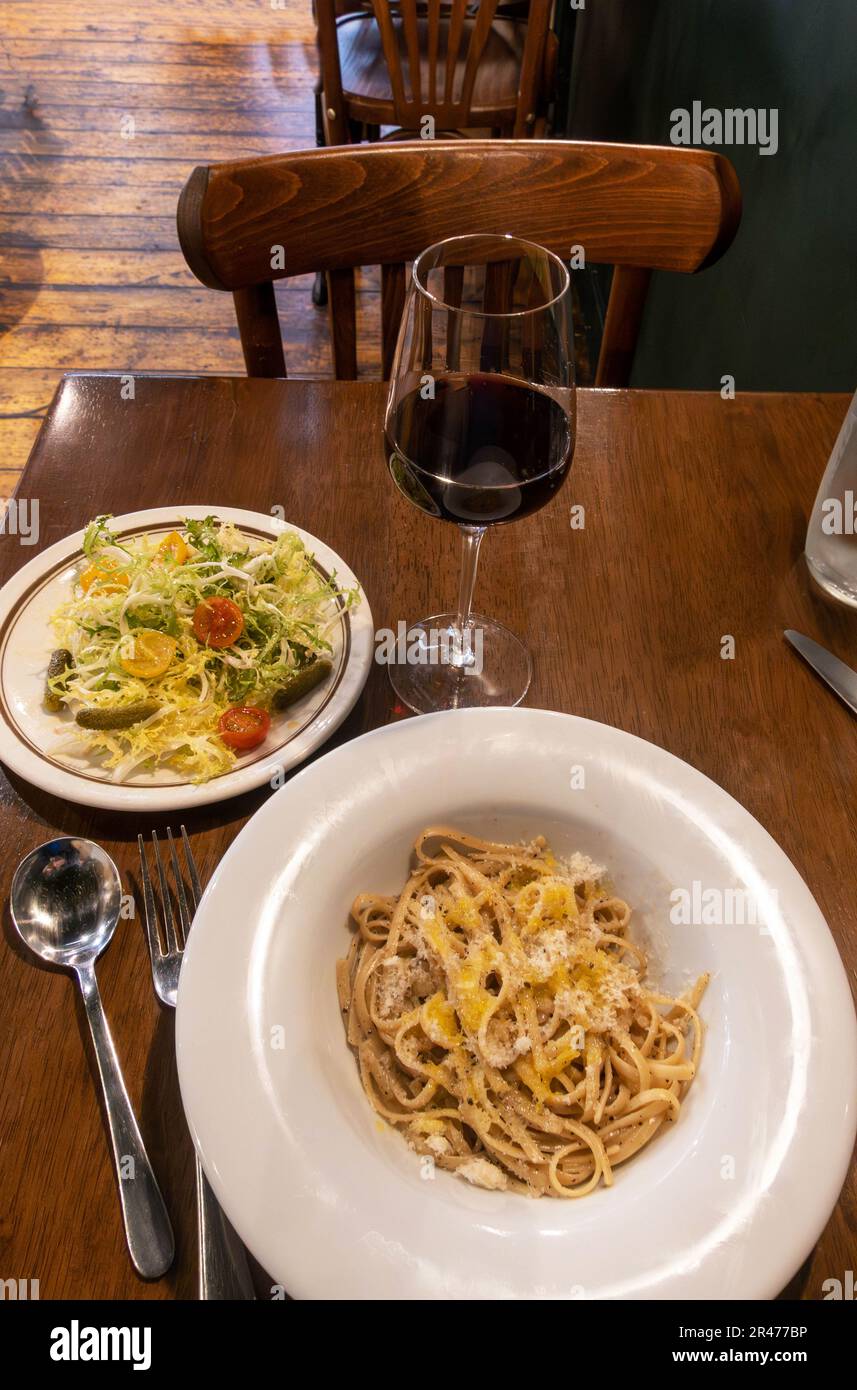Cacio e Pepe pasta with salad and wine Stock Photo