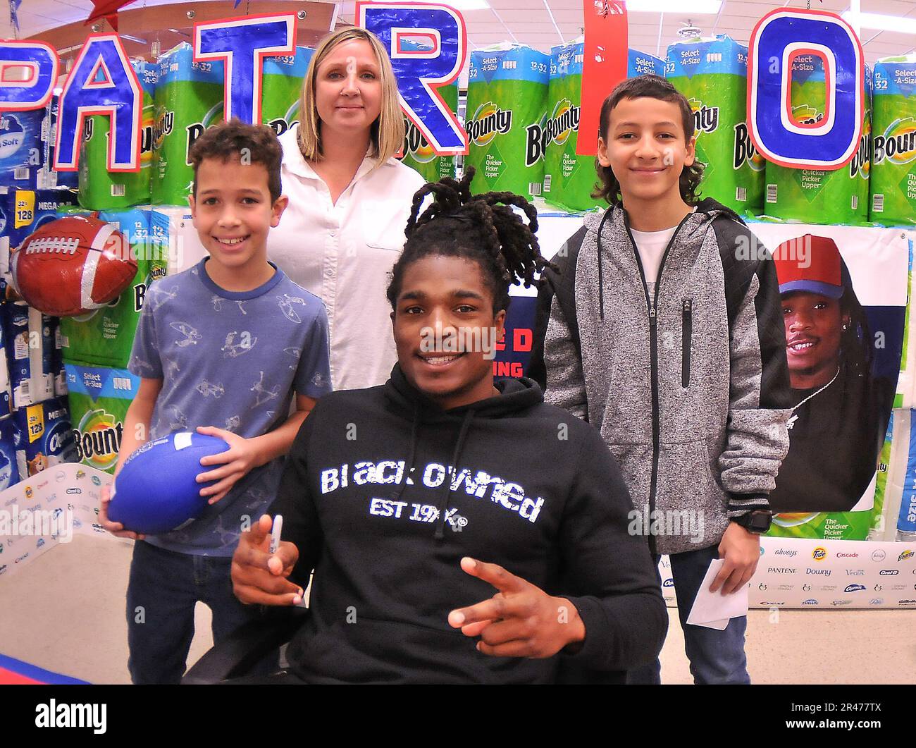 The Rollins family poses for pictures with New England Patriots football player Kyle Dugger during an autograph session Feb. 16 at the Fort Lee Commissary.  More than 100 fans were present for the event that also included giveaways, free hot dogs and sales promotions. Stock Photo