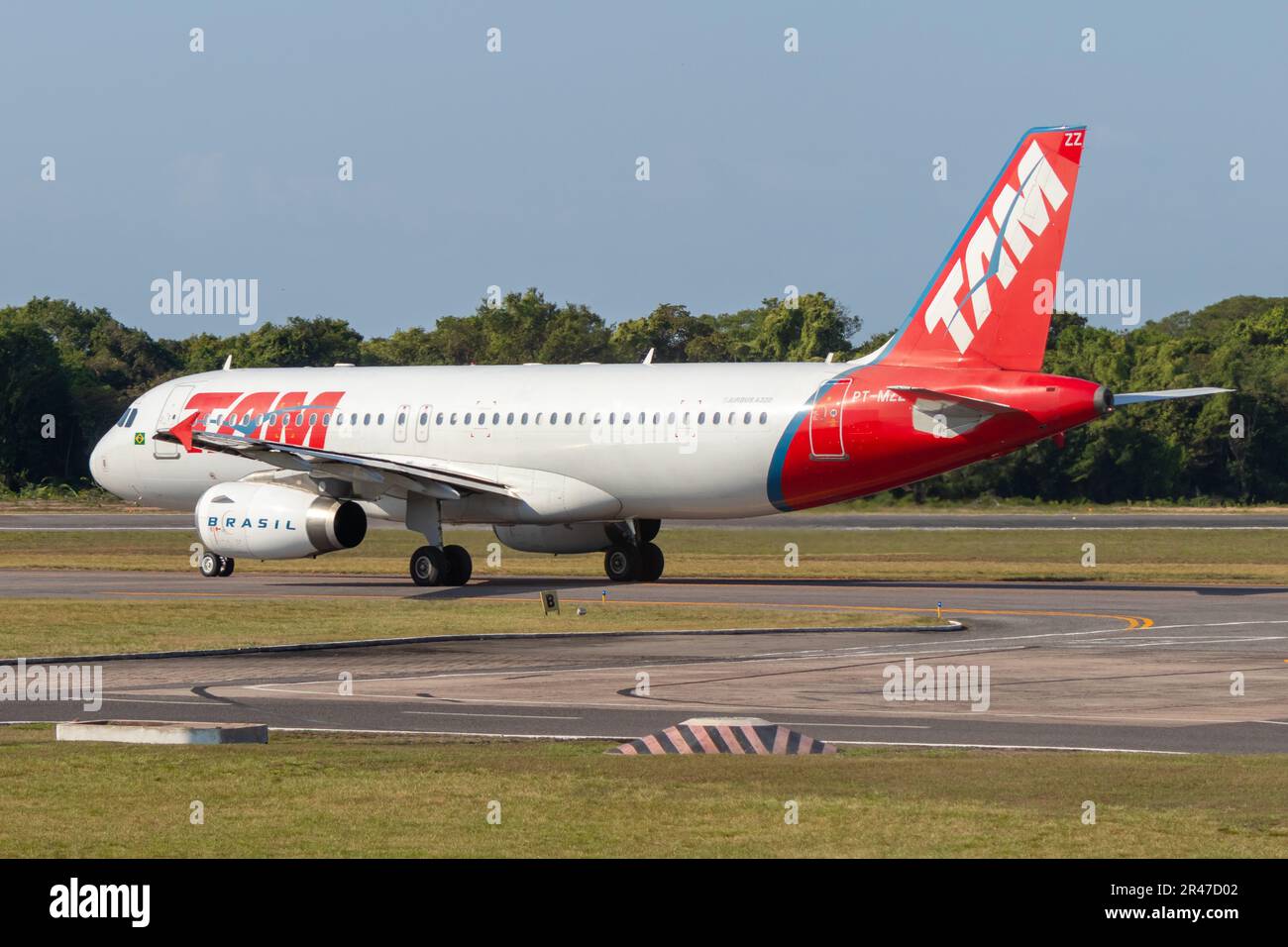 A LATAM plane, still bearing the TAM livery, taxis through the taxiway at Santarem Airport (SBSN). It's an Airbus A320 with registration PT-MZZ Stock Photo