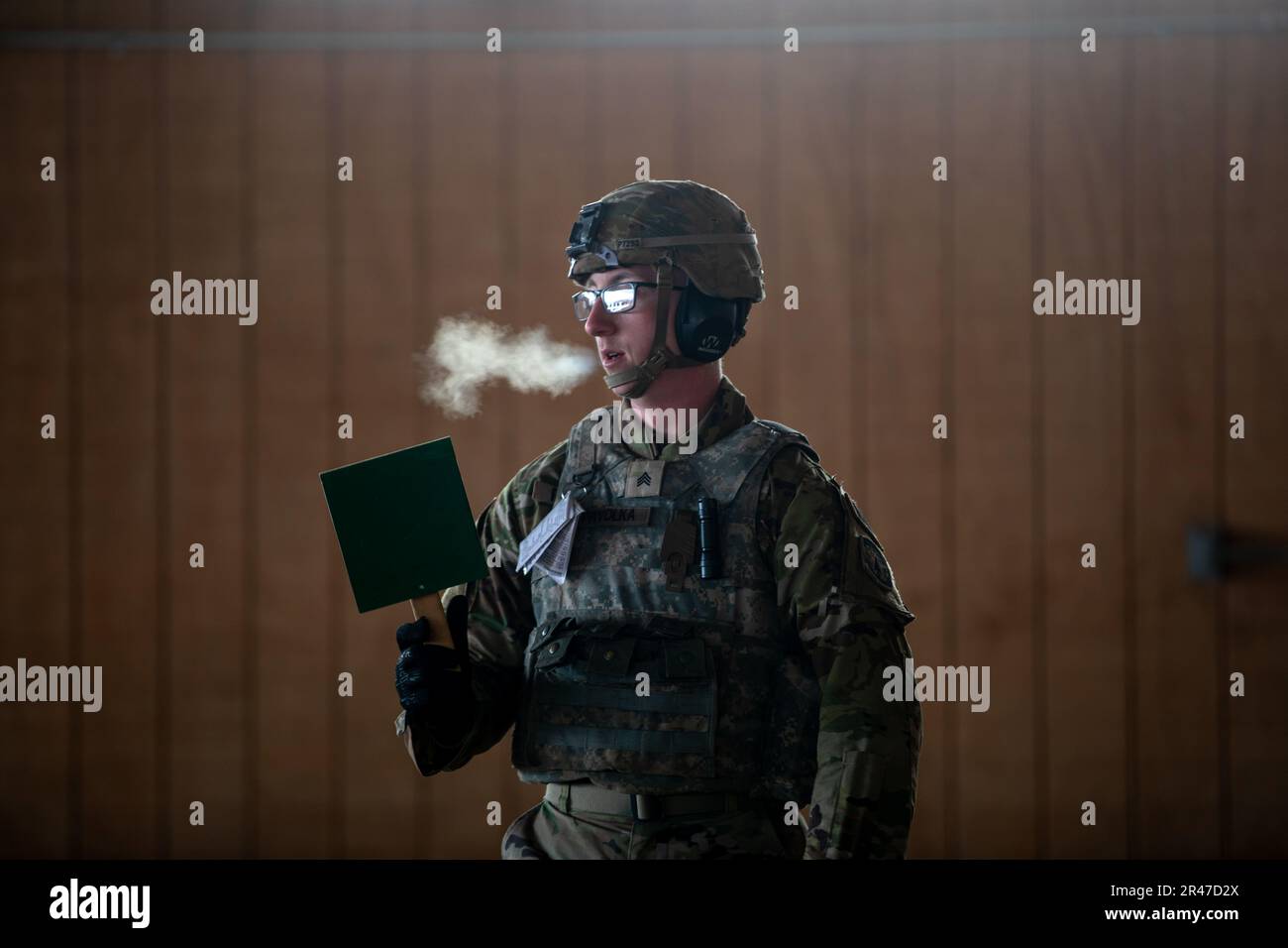 A soldier displays a green flag to signal all clear during grouping and