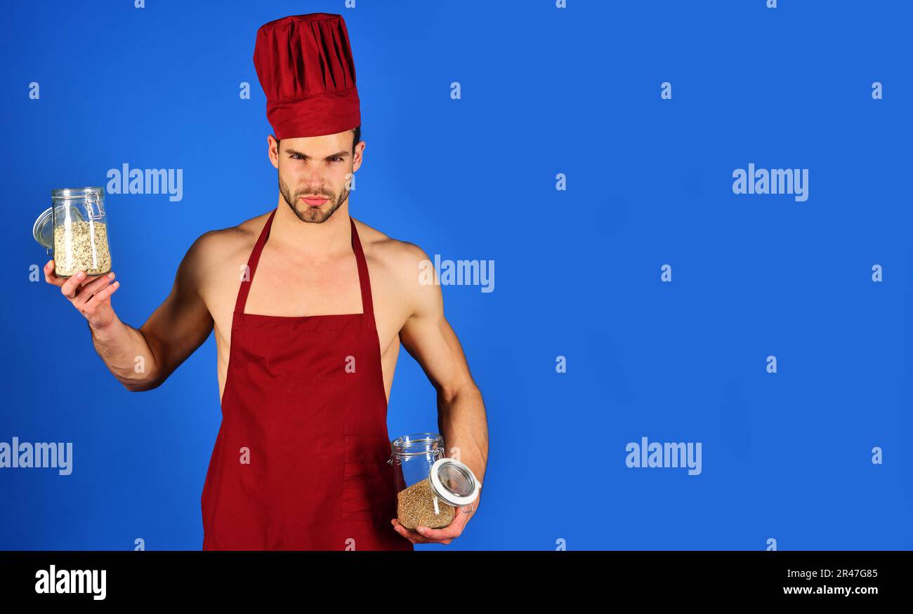 Professional culinary. Male cook in chef hat and apron holds glass jars