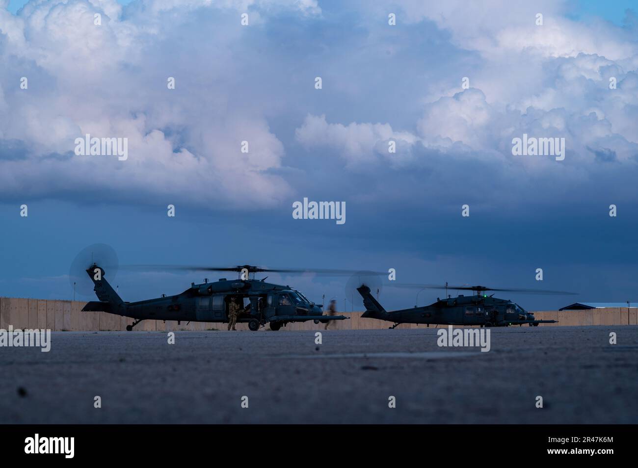 Two U.S. Air Force HH-60 Pave Hawks assigned to the 46th Expeditionary Rescue Squadron prepare to take off for a night operation during a mission rehearsal in support of Exercise Agile Spartan within the U.S. Central Command area of responsibility, March 21, 2023. Exercise Agile Spartan is a combined, joint training exercise that enhances international partnerships and regional security in the USCENTCOM AOR. Stock Photo