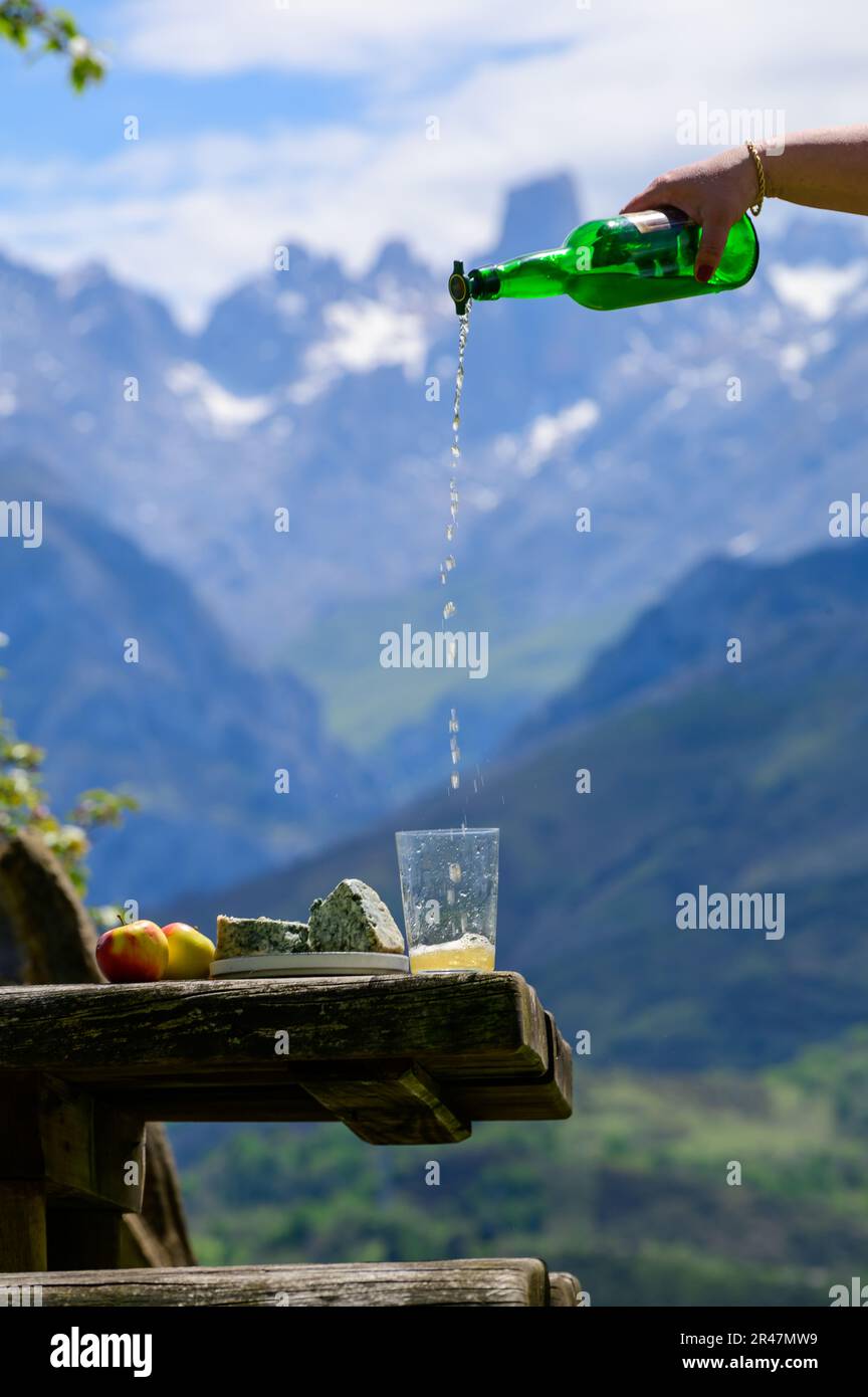 Pouring from high height of natural Asturian cider made from fermented