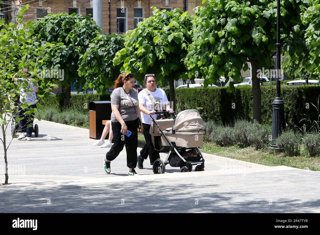 A family walks along the Flower Garden Park at the Mineralnye Vody resort in the Russian Federation. Stock Photo