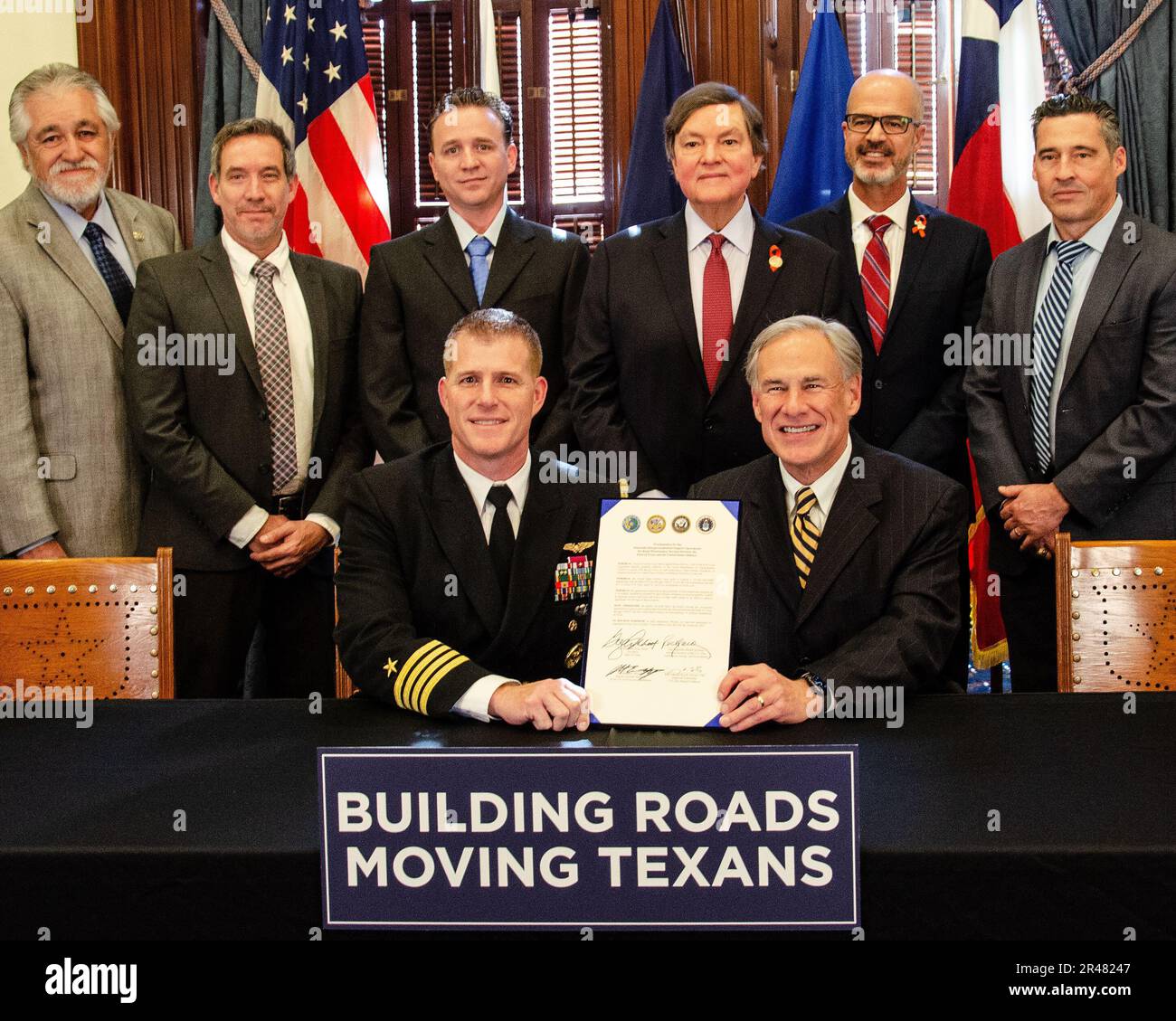 Captain Greg Smith, Navy Region Southeast Chief of Staff, sits with Texas Governor Greg Abbot following the signing of an historic proclamation for the largest Department of Defense Inter Governmental Service Agreement.  The proclamation recognizes the first IGSA with a single partner that will benefit three military branches.  Representatives from the Texas Department of Transportation, U.S. Army, and U.S. Air Force were also on hand for the signing ceremony. Stock Photo