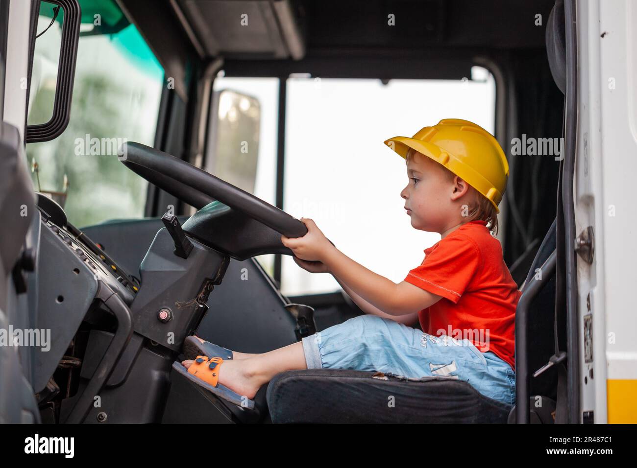 Little boy driving tractor. Son helps father to repair tractor. Involve