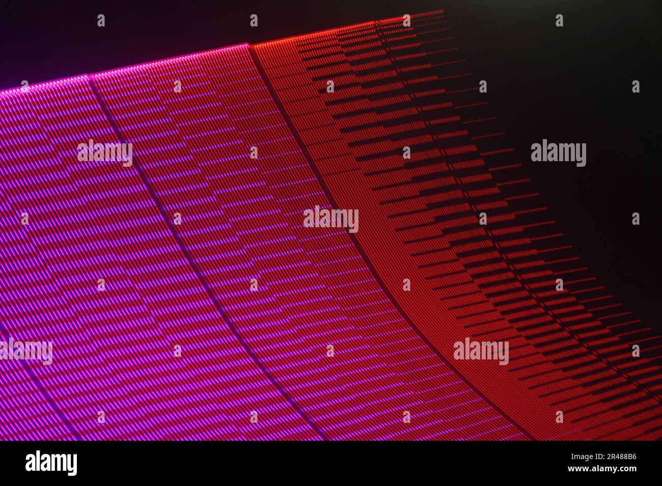 A large display featuring a pattern of purple and red lights radiating outward along distinct lines Stock Photo