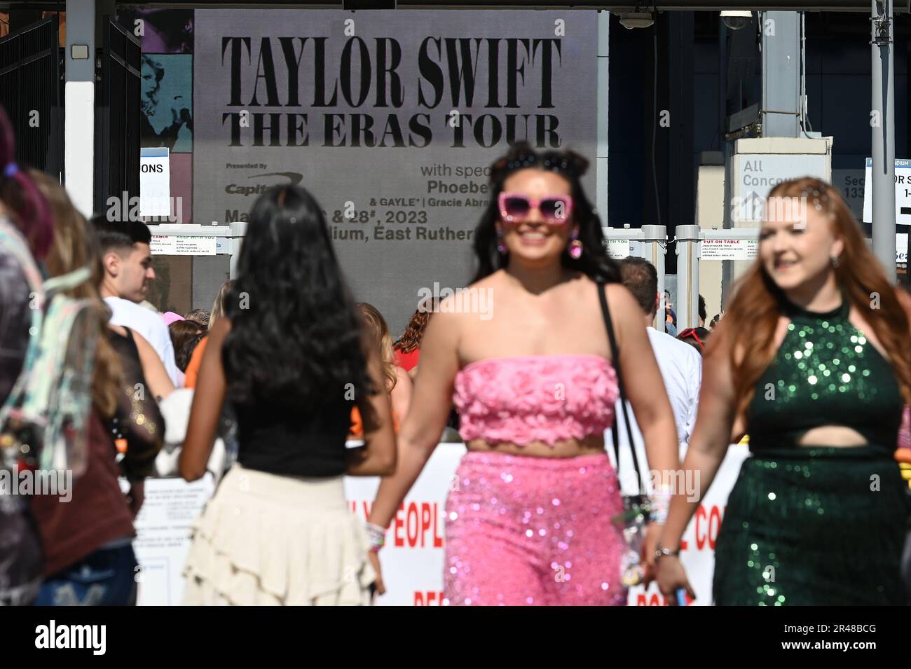 East Rutherford, USA. 26th May, 2023. Two Taylor Swift fans wear decorative  bracelets as one paints the number 13 on the back of the other's hand  before start of the concert at