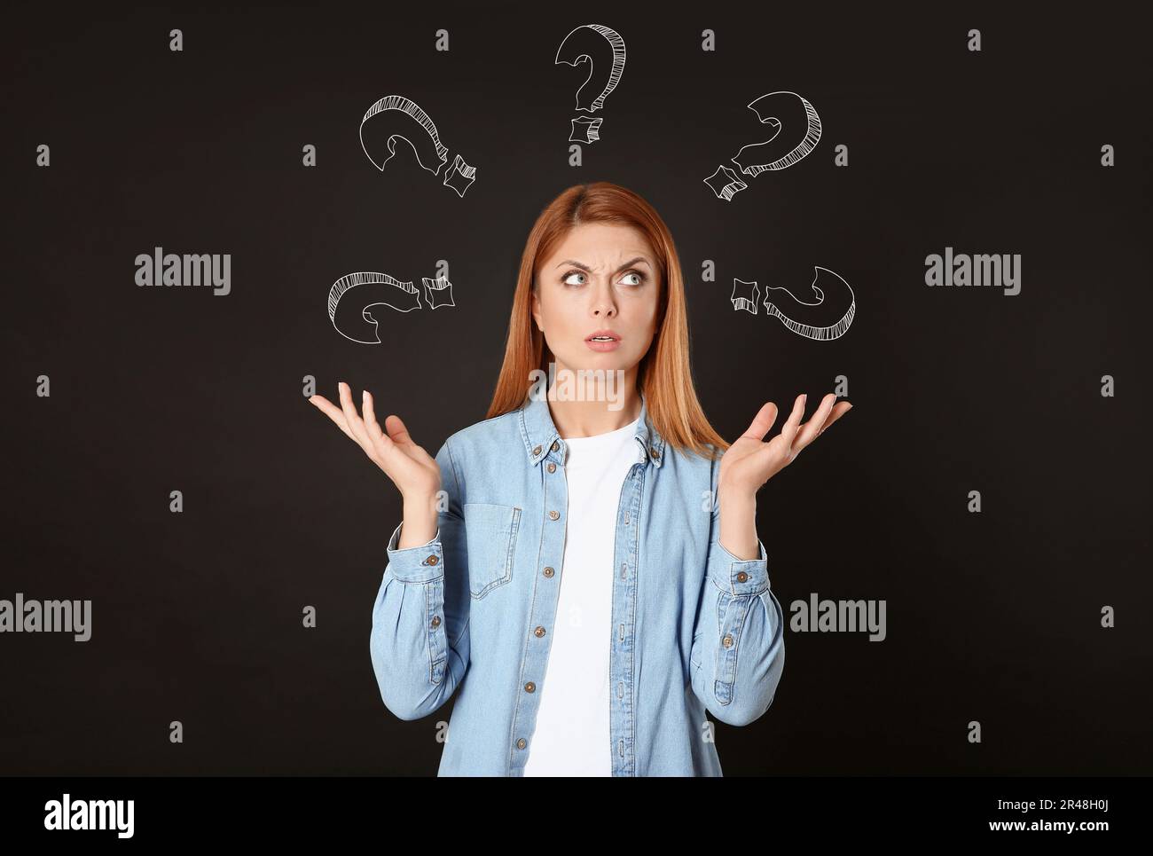 Choice in profession or other areas of life, concept. Making decision, thoughtful woman surrounded by drawn question marks on black background Stock Photo