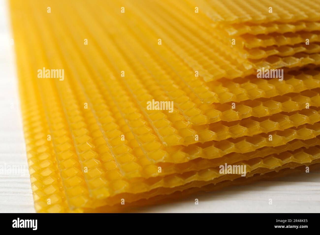 Natural organic beeswax sheets on white wooden table, closeup Stock Photo