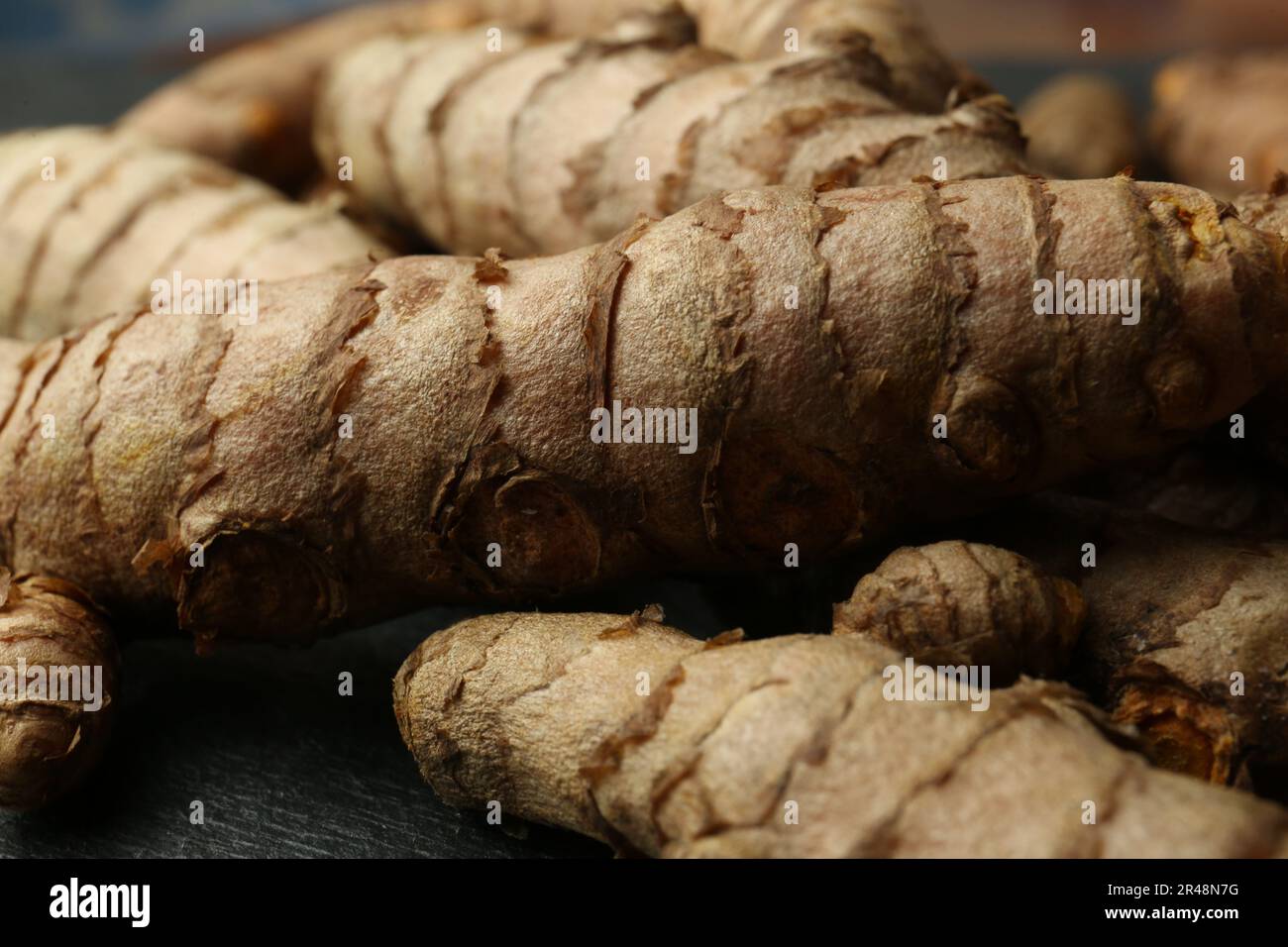 Hard Turmeric Roots Many raw turmeric roots on black textured table, closeup Stock Photo ...