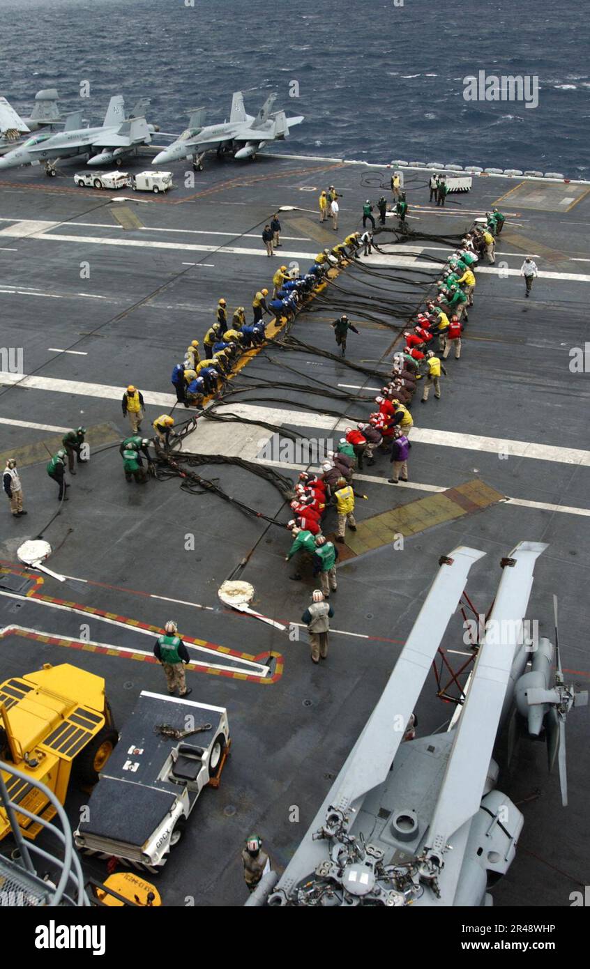 US Navy Flight deck personnel practice rigging the crash barricade on
