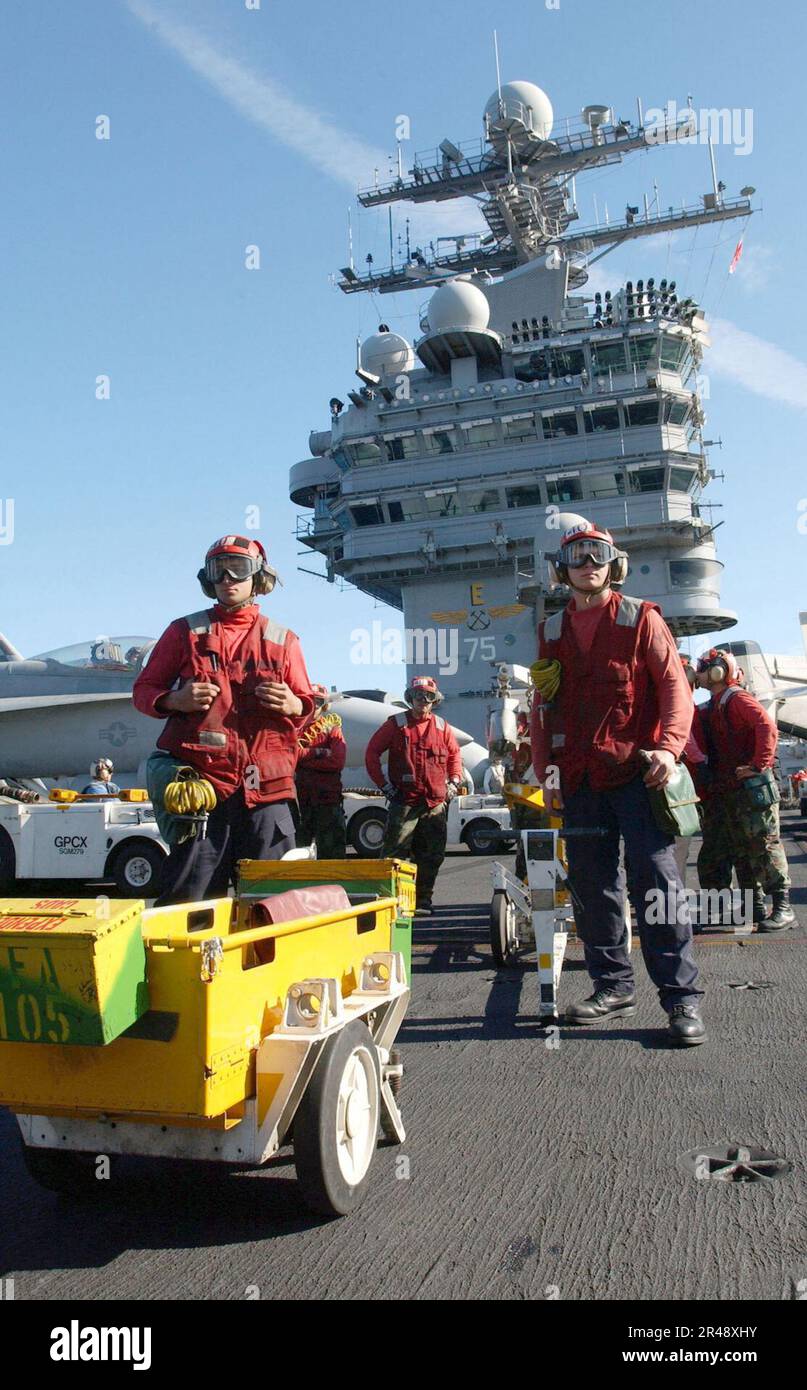 US Navy Aviation Ordnancemen stand by to dearm aircraft weapon systems