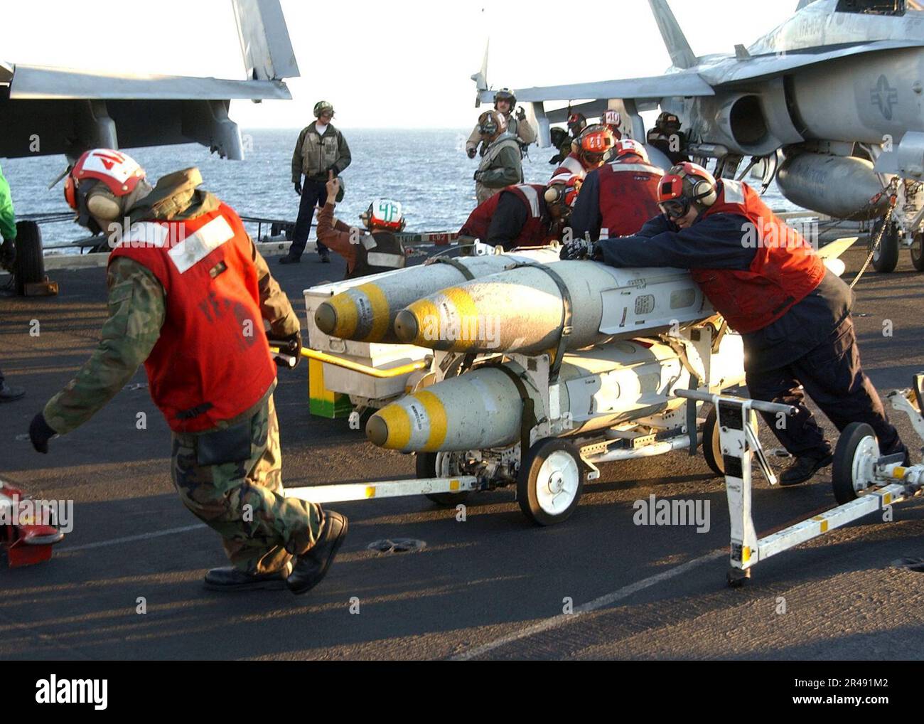 US Navy Weapons handlers on the ship's flight deck aboard USS Harry S ...