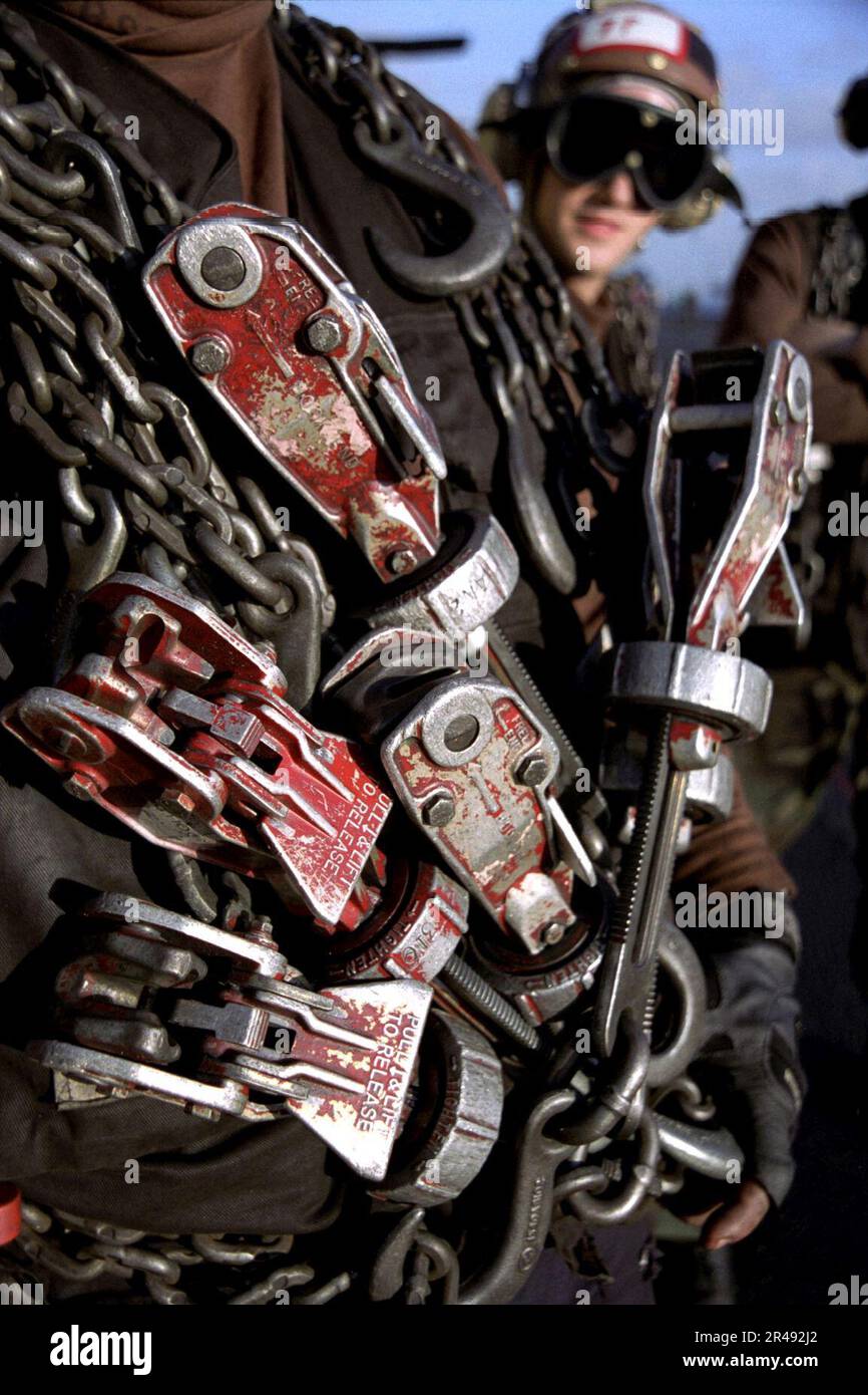 US Navy Flight deck personnel carry Mark One tie down chains for