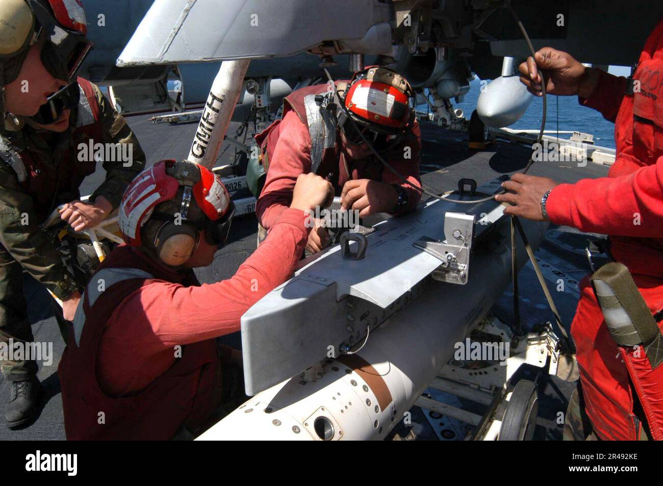 US Navy Aviation Ordnancemen prepare to hoist an Air Launched Guided ...