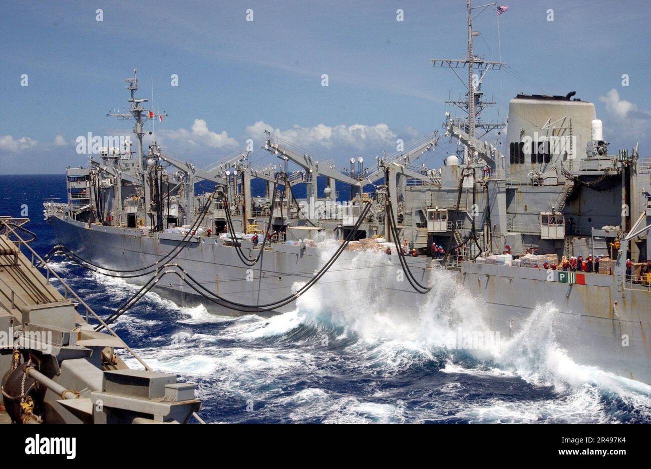 US Navy Waves crash between ships as the fast combat support ship USS