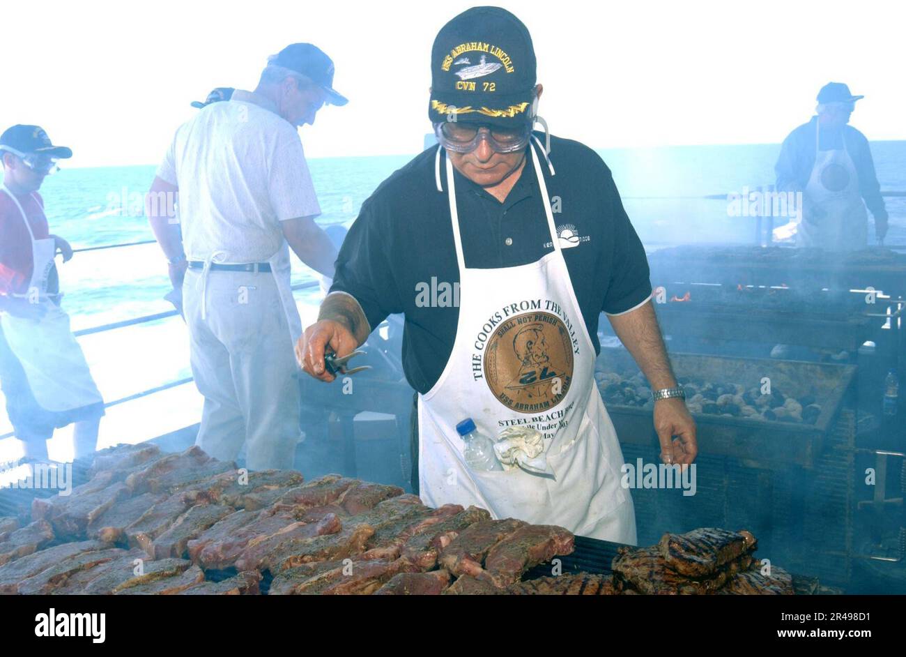 US Navy Volunteers from Harris Ranch Steakhouse prepare steaks for the crew aboard USS Abraham Lincoln (CVN 72) Stock Photo