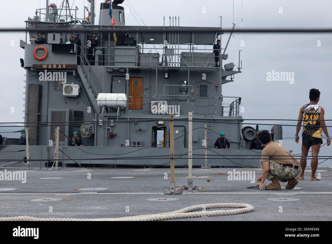 A U.S. Navy Sailor watches from a Navy Roll-On/Roll-Off Discharge Facility as Philippine BRP Waray LC-288 moors next to it during a combined joint logistics over-the-shore offload in preparation for Balikatan 23 at Camp Agnew, Casiguran, Philippines, April 6, 2023. Balikatan is an annual exercise between the Armed Forces of the Philippines and U.S. military designed to strengthen bilateral interoperability, capabilities, trust, and cooperation built over decades shared experiences. Stock Photo