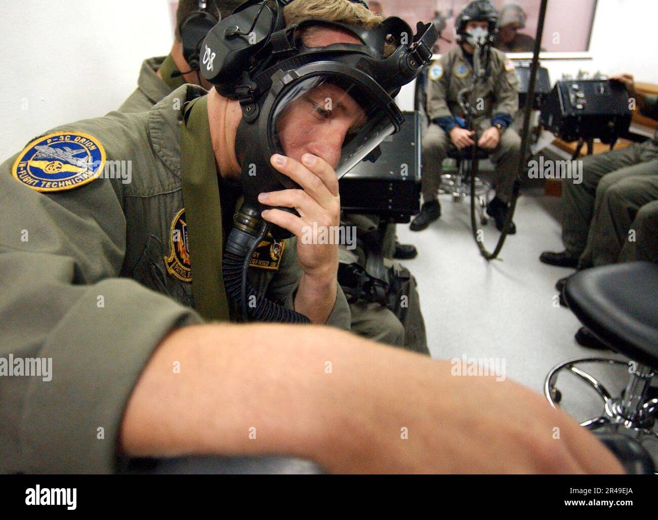 US Navy Aviation Electronics Technician 1st Class checks his oxygen mask before beginning a test in the low pressure chamber at the Aviation Survival Training Center Stock Photo