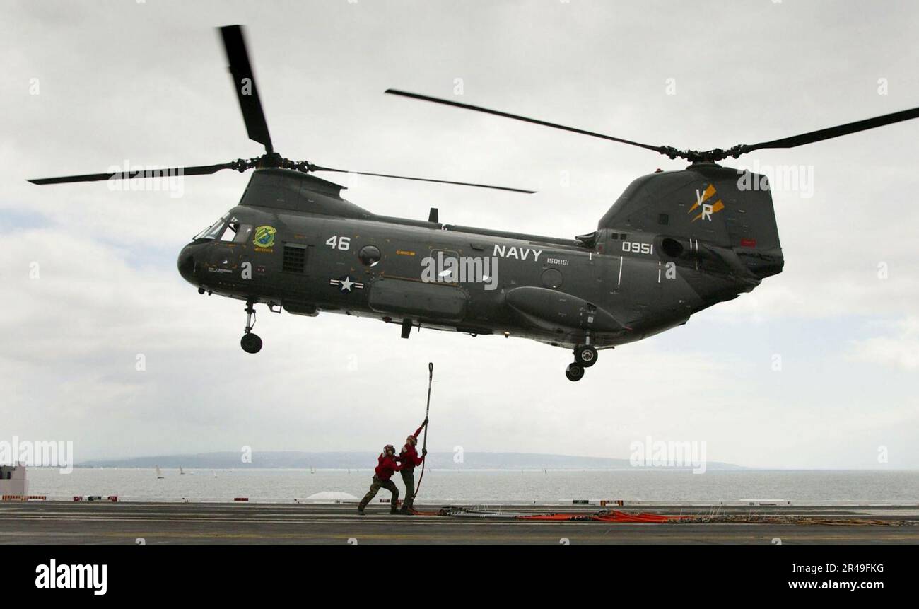 US Navy Aviation Ordnancemen attach a cargo pendant to a CH-46 Sea ...