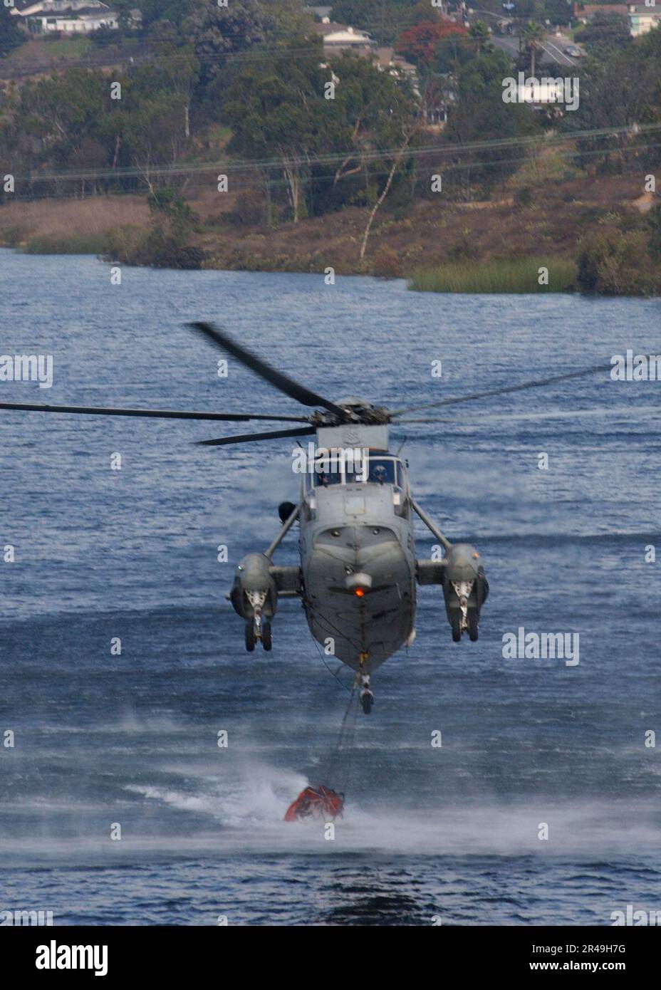 US Navy A UH-3H Sea King helicopter loads its Bambi bucket Stock Photo