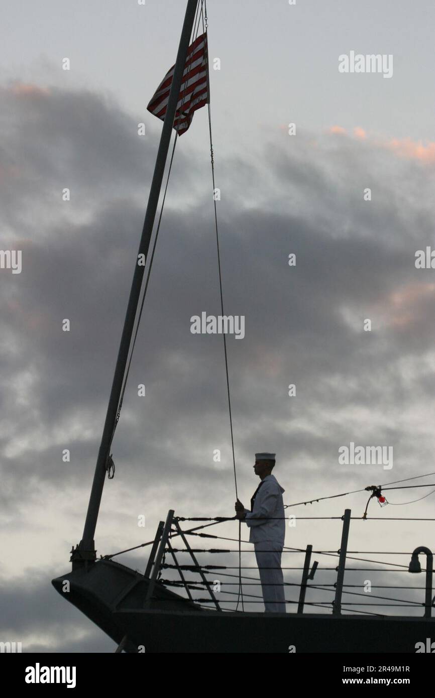 US Navy A watch stander conducts evening colors aboard the newly