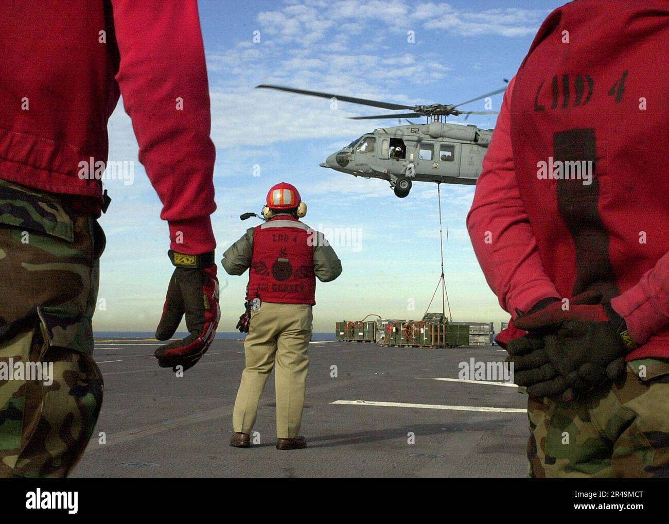 US Navy Aviation Ordnancemen wait to retrieve crates of ammunition on