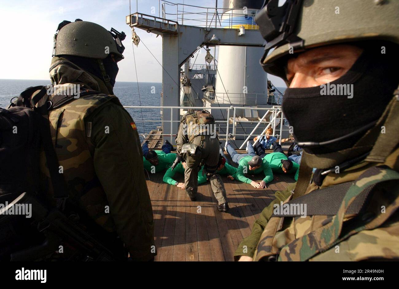 US Navy Spanish Special Operations Forces (SOF) soldiers stand guard over role players aboard the Military Sealift Command (MSC) combat stores ship USNS Saturn (T-AFS 10) Stock Photo