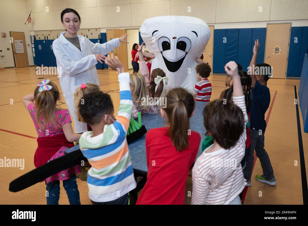 Tech. Sgt. Katsiaryna Durant, 66th Medical Squadron Dental Clinical chief of preventive dentistry, and  “Mr. Toothy” visit children at the primary school at Hanscom Air Force Base, Mass., Feb 14. The children  participated in games and activities to promote better dental care and to observe National Children’s  Dental Health Month. Stock Photo