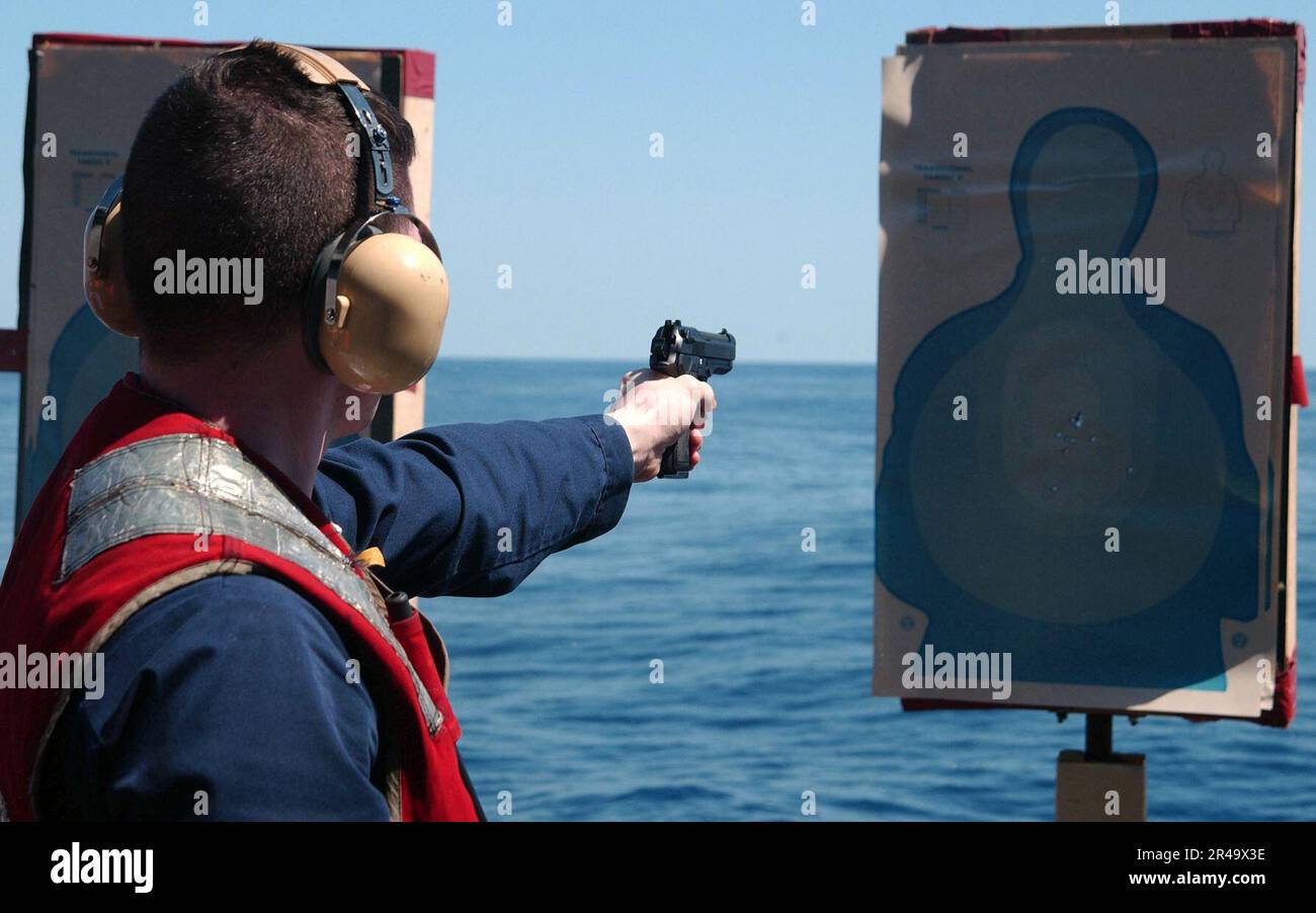 US Navy Ens. shoots a 9mm pistol during a pistol qualification shoot