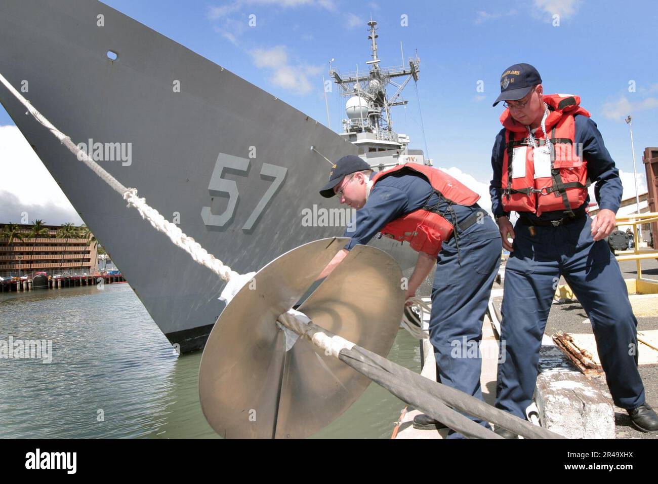 US Navy Seaman install a rat guard on a bow mooring line Stock Photo