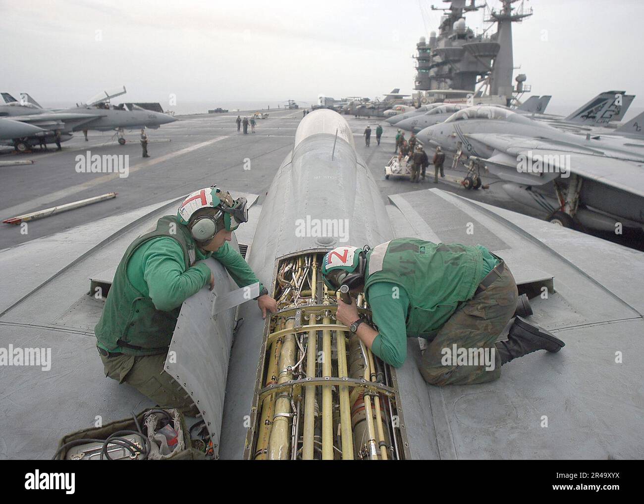 US Navy Sailors repair antenna wiring in the turtle back of an F-14B