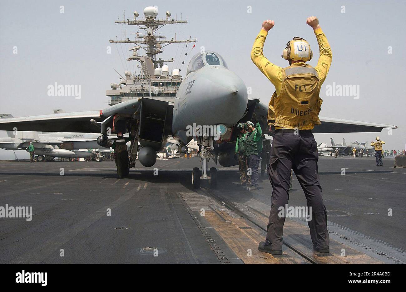 US Navy Aviation Boatswain's Mate Airman directs an F14B Tomcat Stock