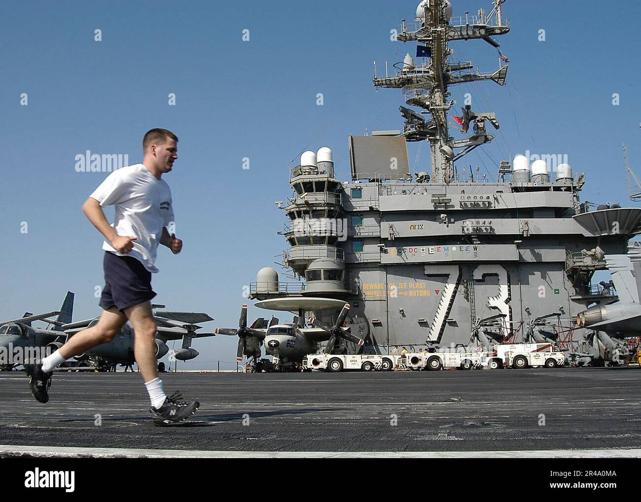 US Navy  Lt. j.g. get in his exercise routine as he runs on the flight deck, during a no-fly day aboard USS George Washington (CVN 73). Stock Photo