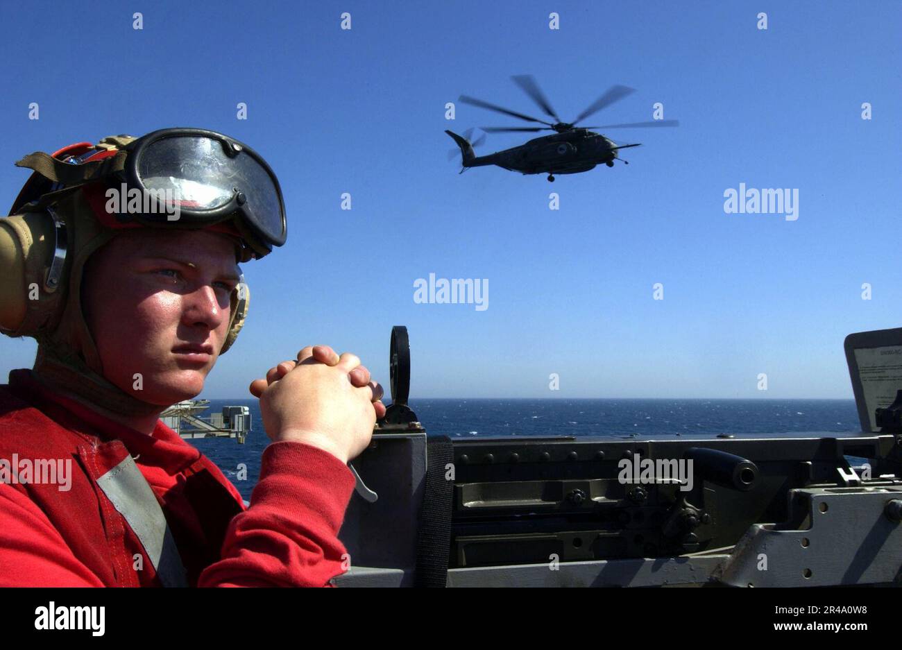 US Navy Aviation Machinists Mate mans a .50 caliber machine gun mount