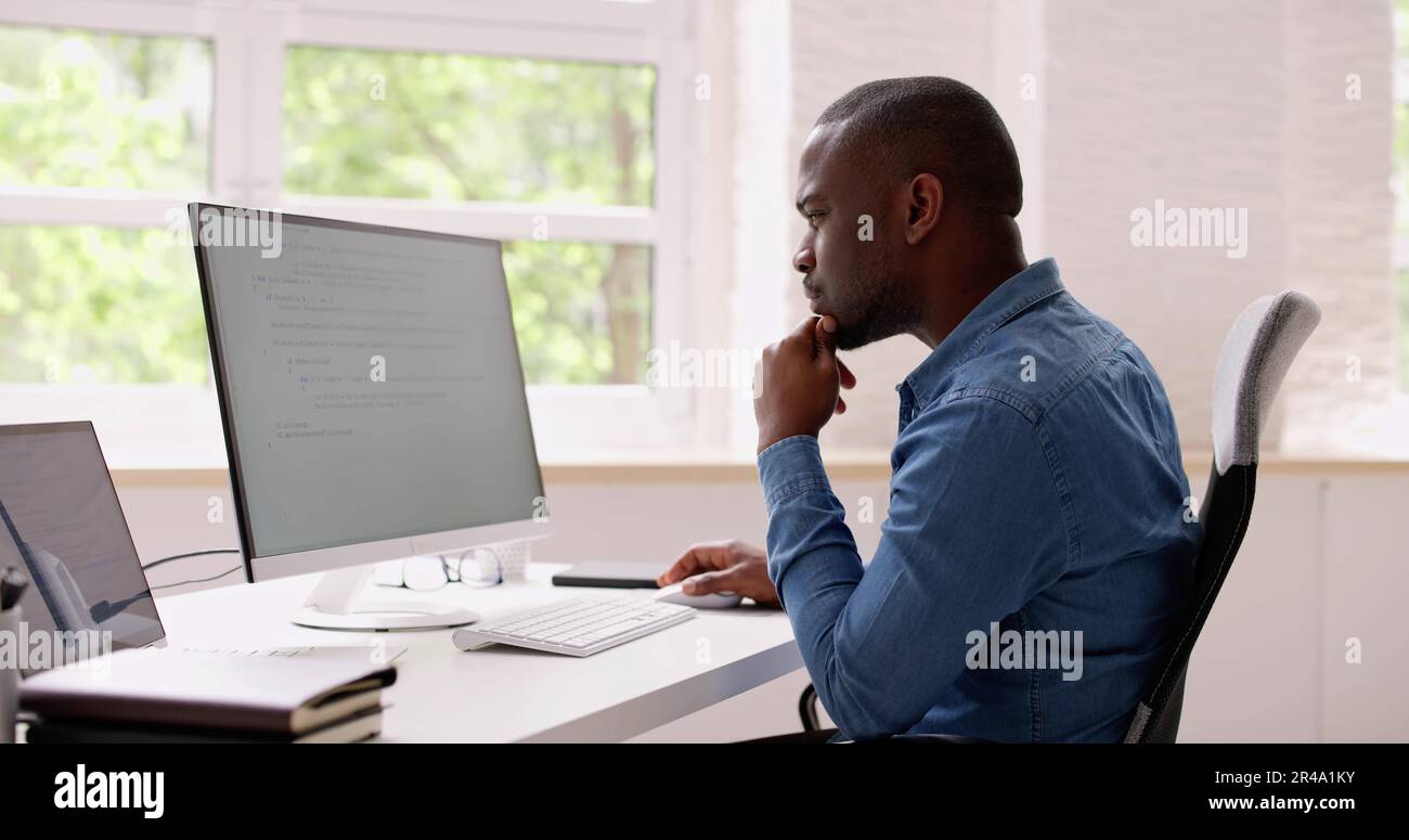 Computer Programmer Writing Program Code On Computer In Office Stock Photo