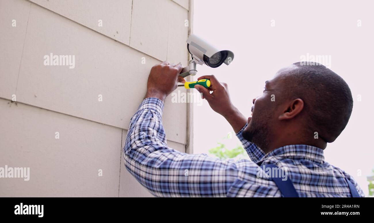 African American Handyman With CCTV Camera, Security System Stock Photo