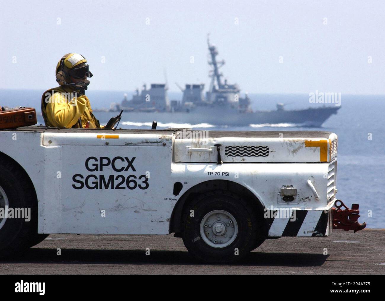 US Navy Aviation Boatswain's Mate 1st Class prepares to move an aircraft on the flight aboard