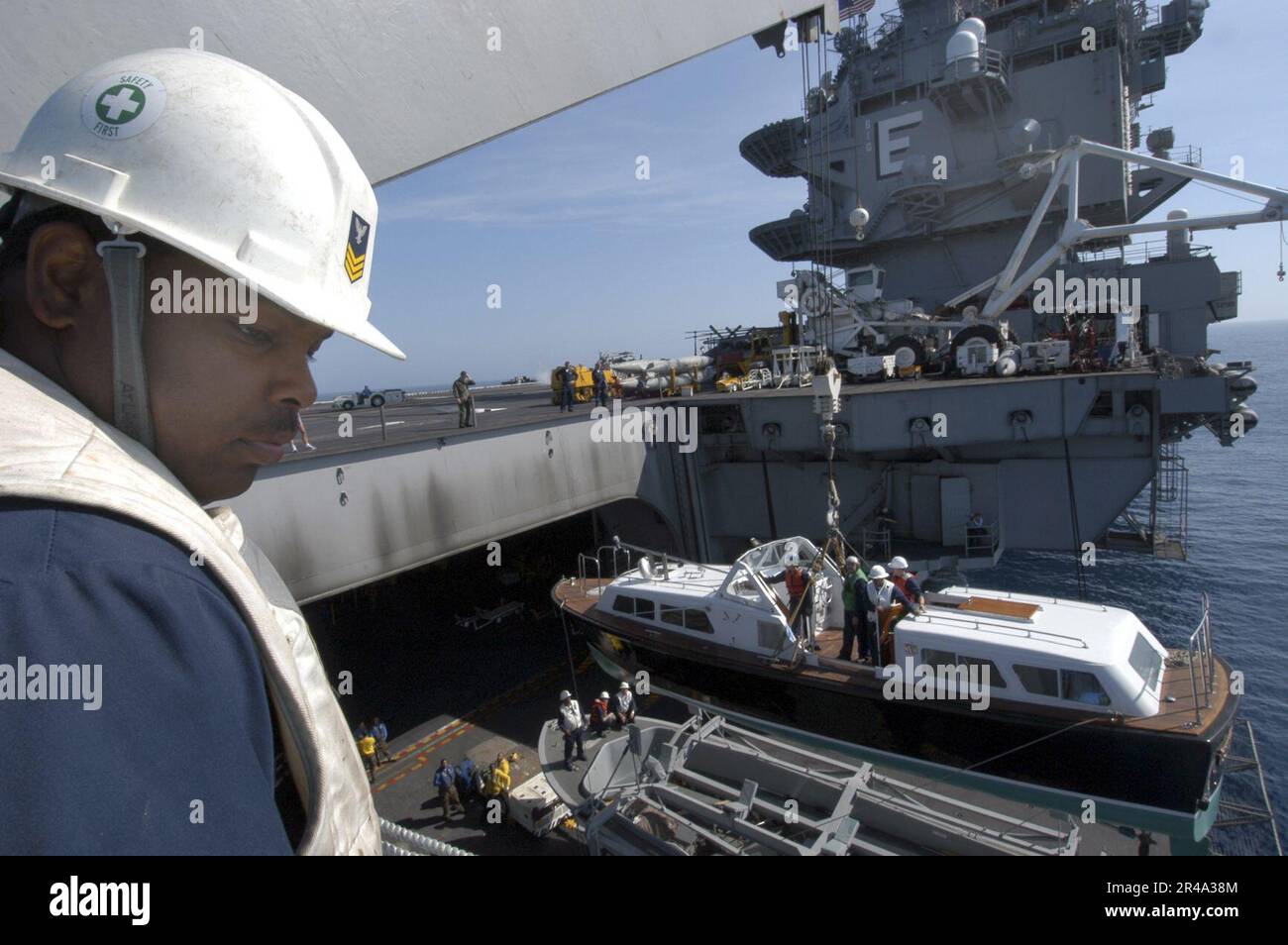 US Navy Boatswain's Mate 1st Class ensures the safe lifting of the admiral's barge from the