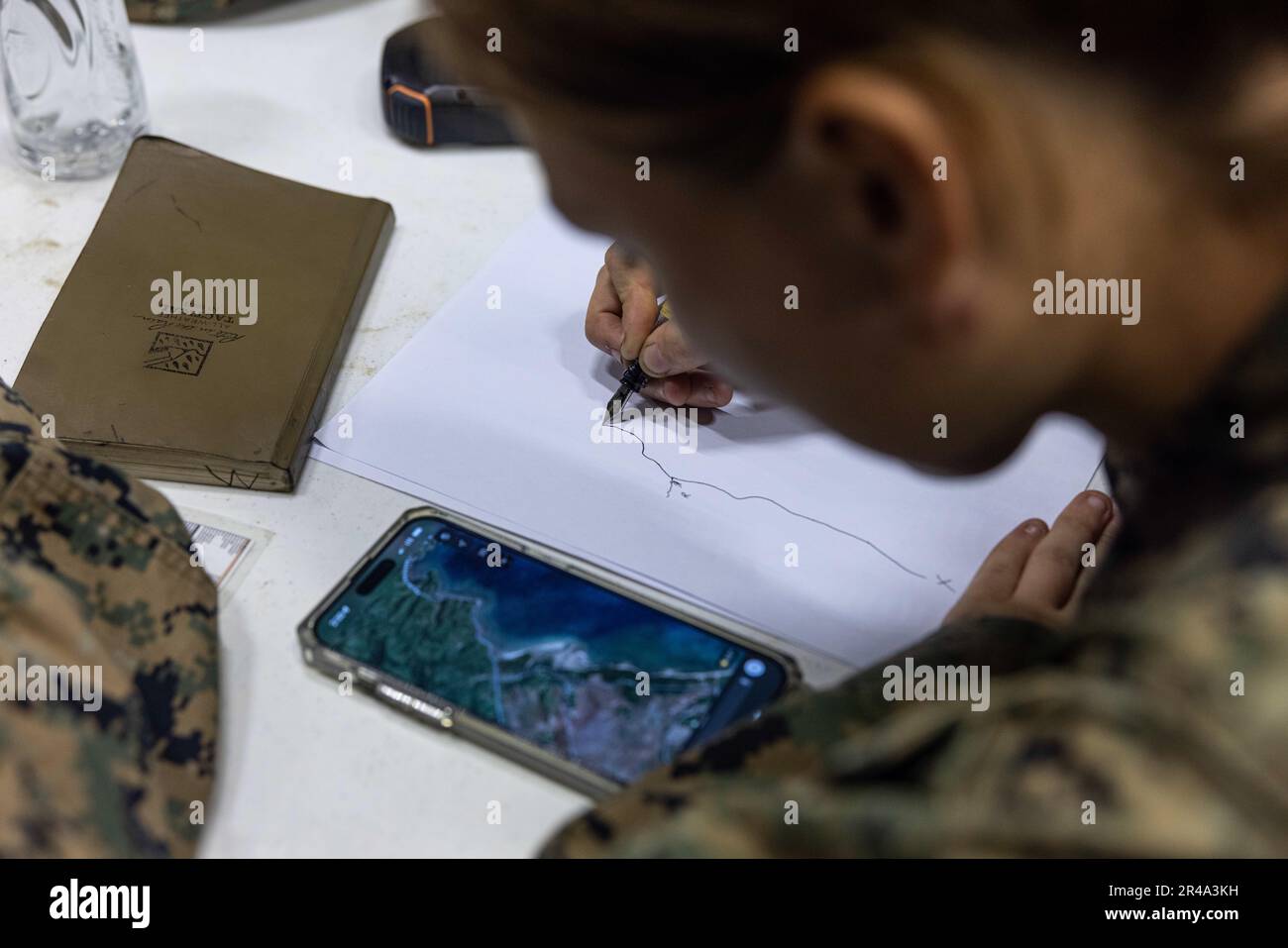 U.S. Marine Corps Lance Cpl. Kaitlyn Warner, a motor trasnport operator with 3rd Landing Support Battalion, and a native of Henderson, Nevada, sketches a convoy route during a combined joint logistics over-the-shore offload in preparation for Balikatan 23 at Camp Agnew, Casiguran, Philippines, April 6, 2023. Balikatan is an annual exercise between the Armed Forces of the Philippines and U.S. military designed to strengthen bilateral interoperability, capabilities, trust, and cooperation built over decades shared experiences. Stock Photo